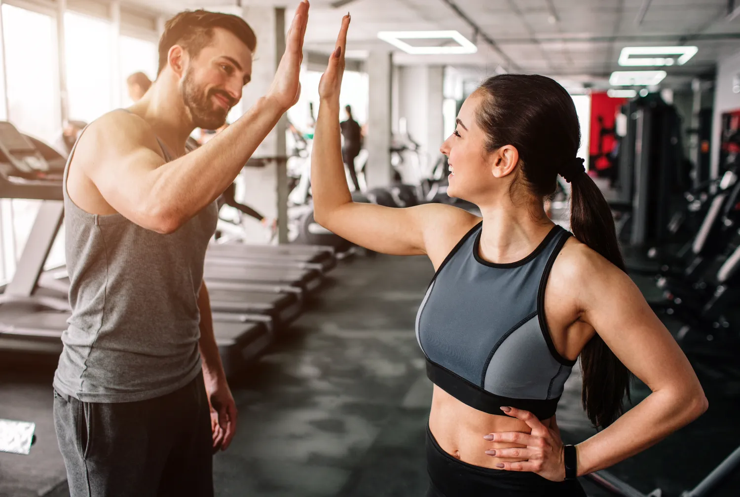 Deux personnes se tapent dans la main à la gym