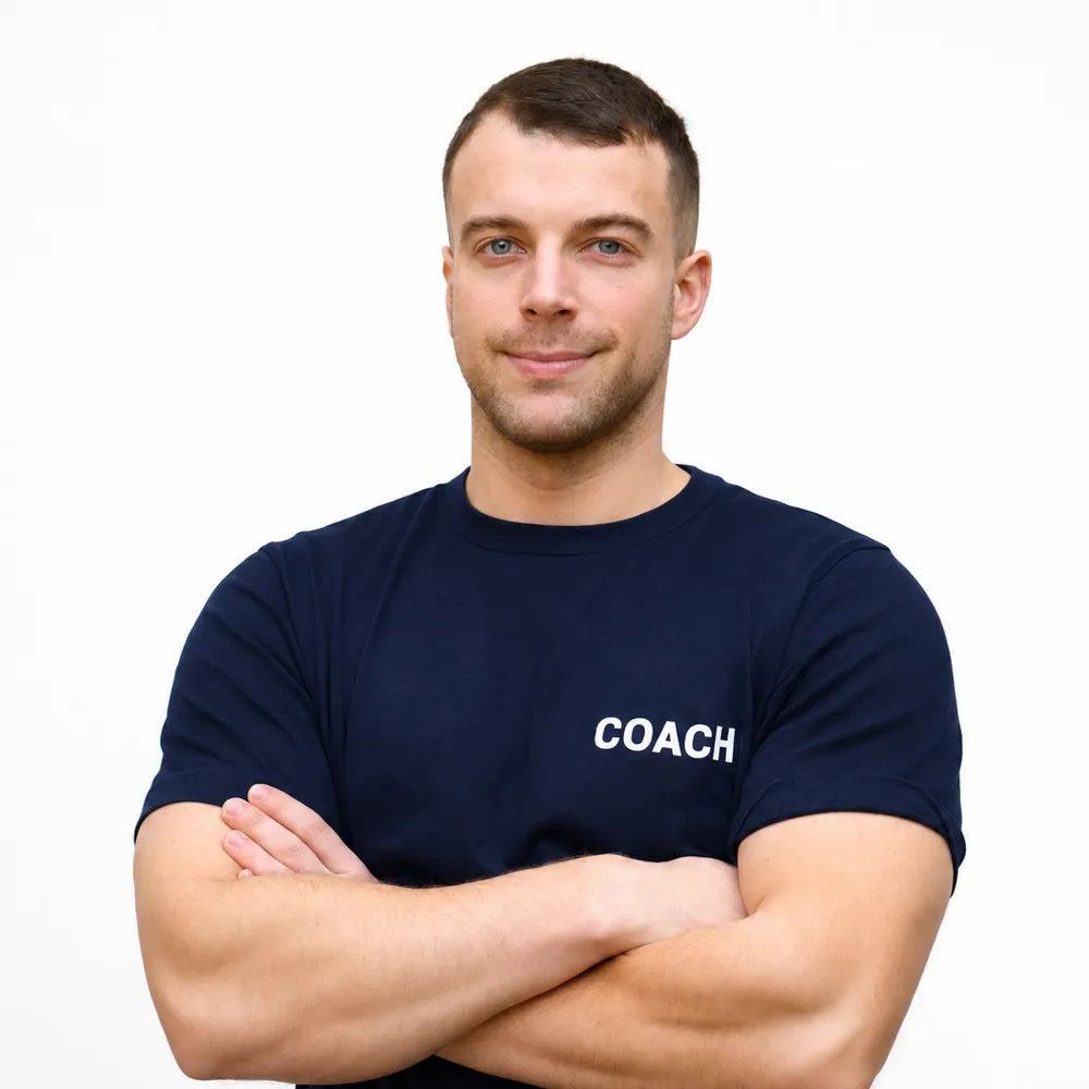 Homme en t-shirt 'coach' croisant les bras